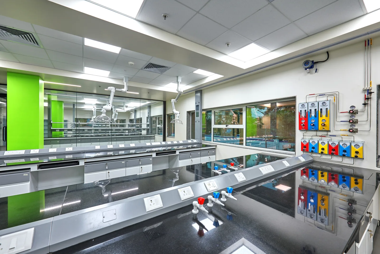 Research laboratory with fume hood, snorkel extractors and colour-coded gas manifold panels